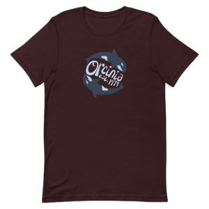 Oxblood black short-sleeve t-shirt featuring two orca whales swimming in a circle. Text between them reads "Orcinia, est. 1979."